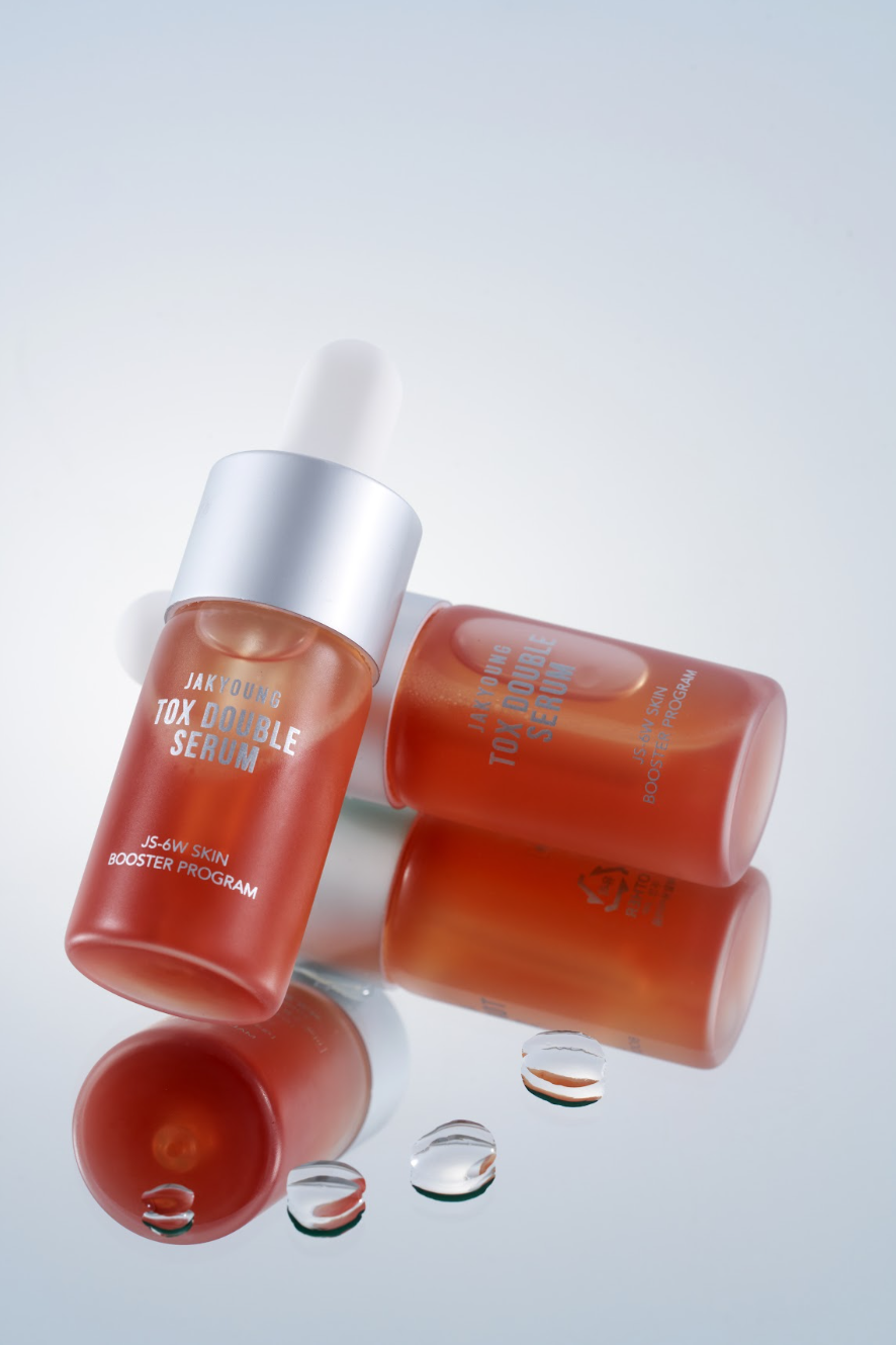 Two amber glass skincare dropper bottles with silver caps and white labels.